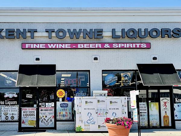 The Kent Towne Liquors shopfront in daylight, a white brick unit with a black and pink sign reading Fine Wine, Beer and Spirits.